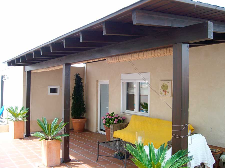 Porche de entrada de madera adosado a fachada diseñado y fabricado a medida por Pérgolas La Arboleda.